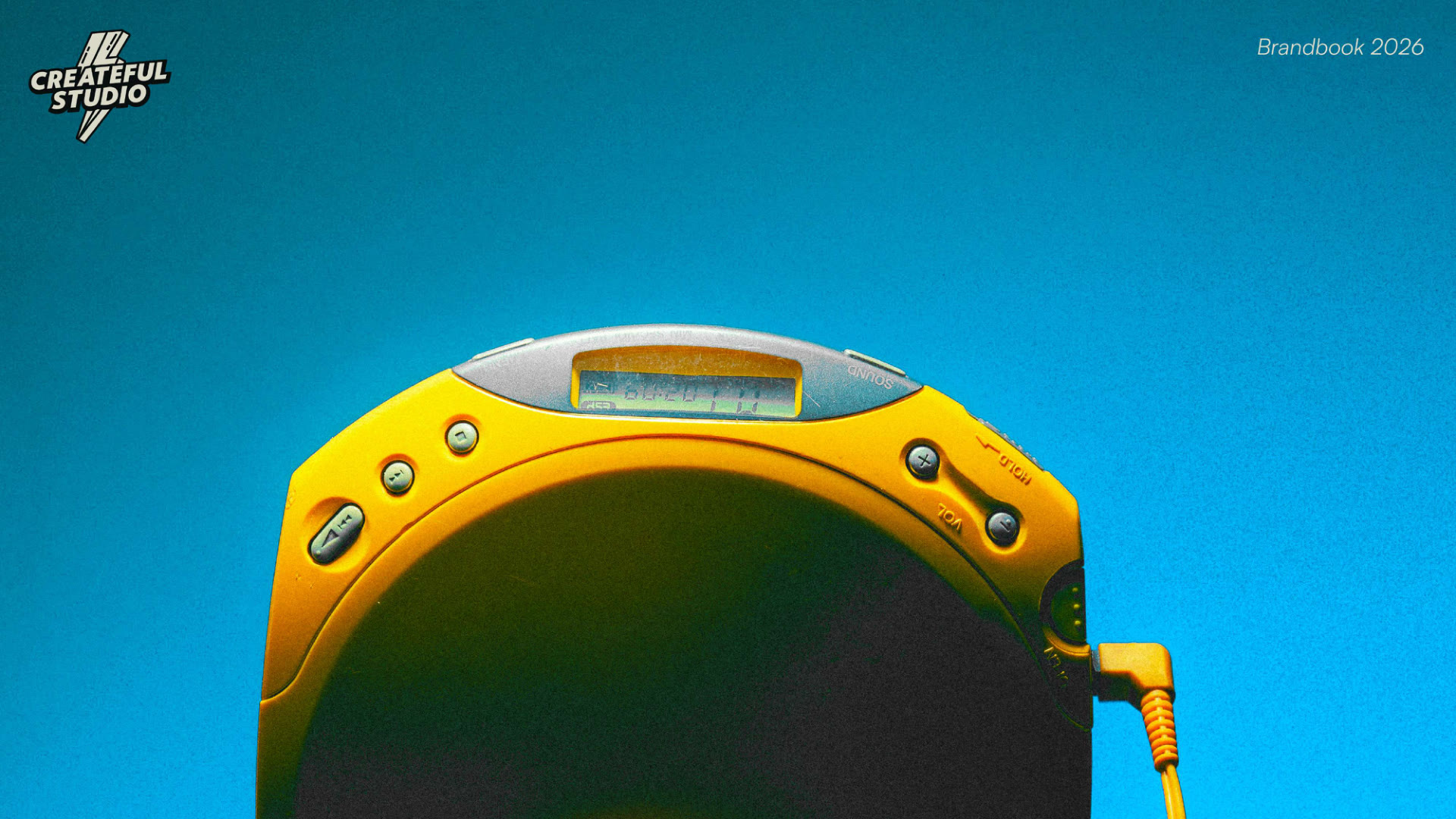 Discman amarelo sobre fundo azul, imagem da marca Createful Studio